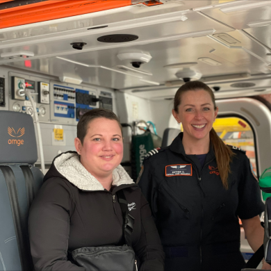 Julie sitting in a helicopter with Ornge Paramedic, Esther