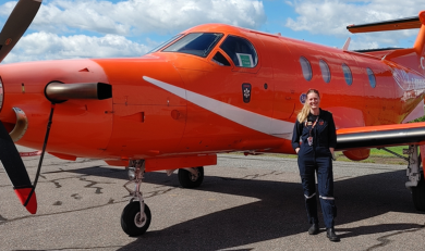 Beth standing next to a fixed wing aircraft