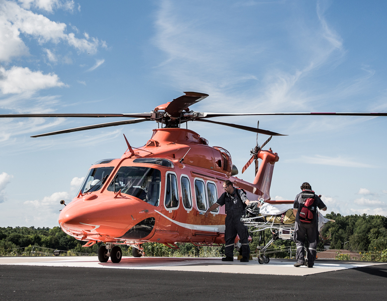 A group of paramedics bringing an Ornge patient on a gurney into an Ornge helicopter