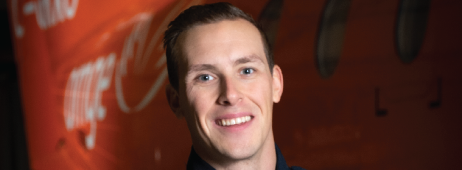 A paramedic in uniform standing in front of an orange plane