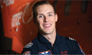 Un ambulancier en uniforme debout devant un avion orange