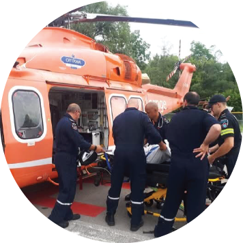 paramedics loading a patient into an orange helicopter