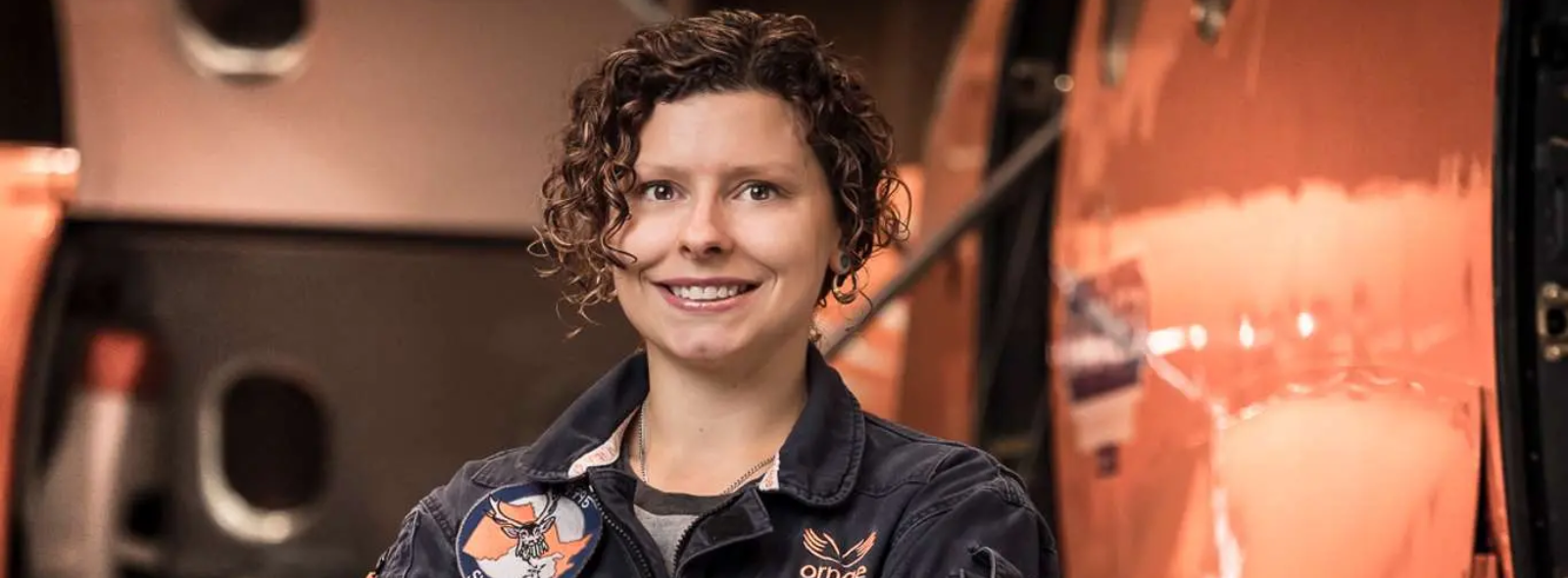 Vanessa standing in front of an Ornge fixed-wing aircraft