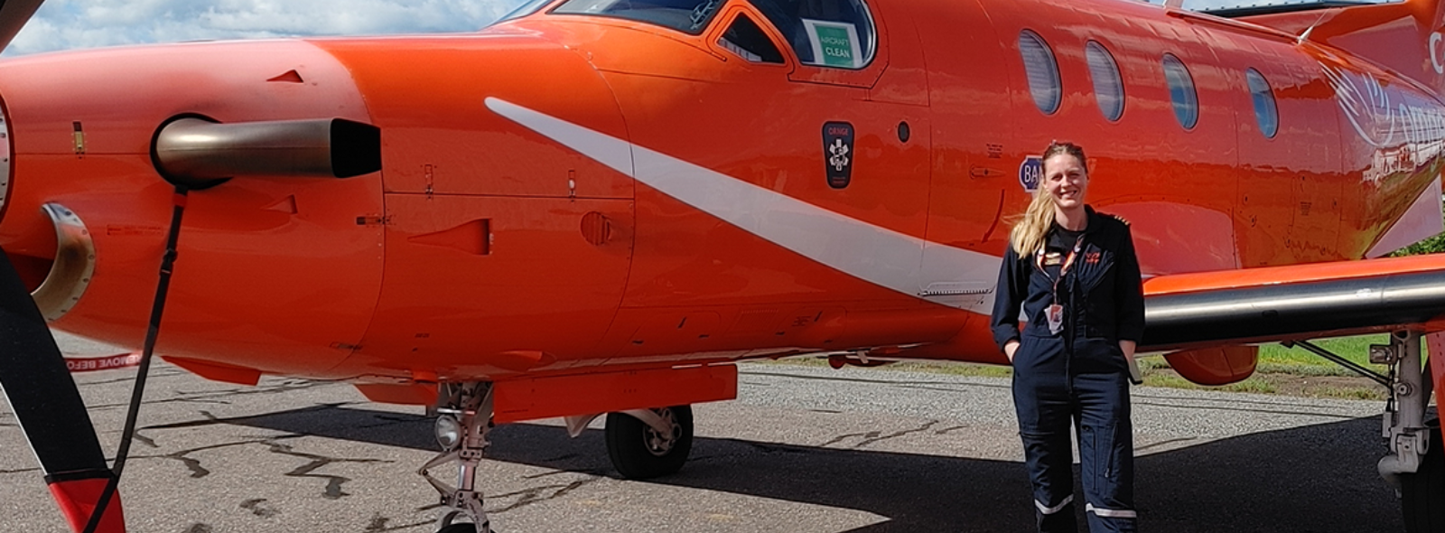 Beth standing next to a fixed wing aircraft