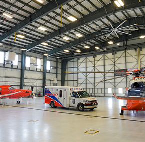 An Ornge PC 12 plane, AW139 helicopter and an ambulance are parked inside the Sudbury hangar.