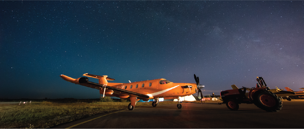 orange plane on the tarmac with stars in the sky