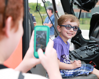 A child posing for a photo while sitting in an Ornge helicopter