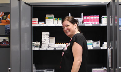 Catherine Dawes debout devant des médicaments