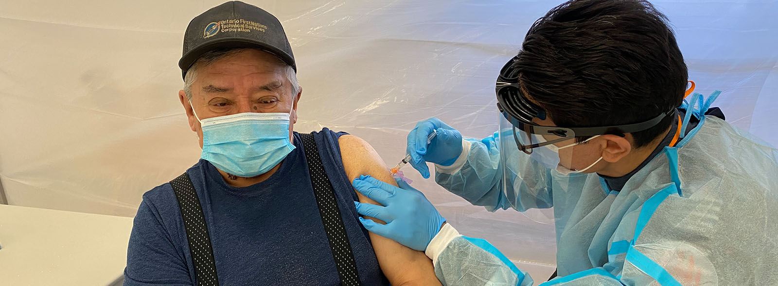 Luke Gull, 71, from Weenusk First Nation (Peawanuck) receiving his COVID-19 vaccination from Critical Care Paramedic Howie