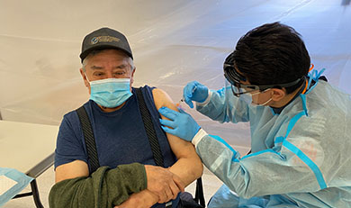 Luke Gull, 71, from Weenusk First Nation (Peawanuck) receiving his COVID-19 vaccination from Critical Care Paramedic Howie
