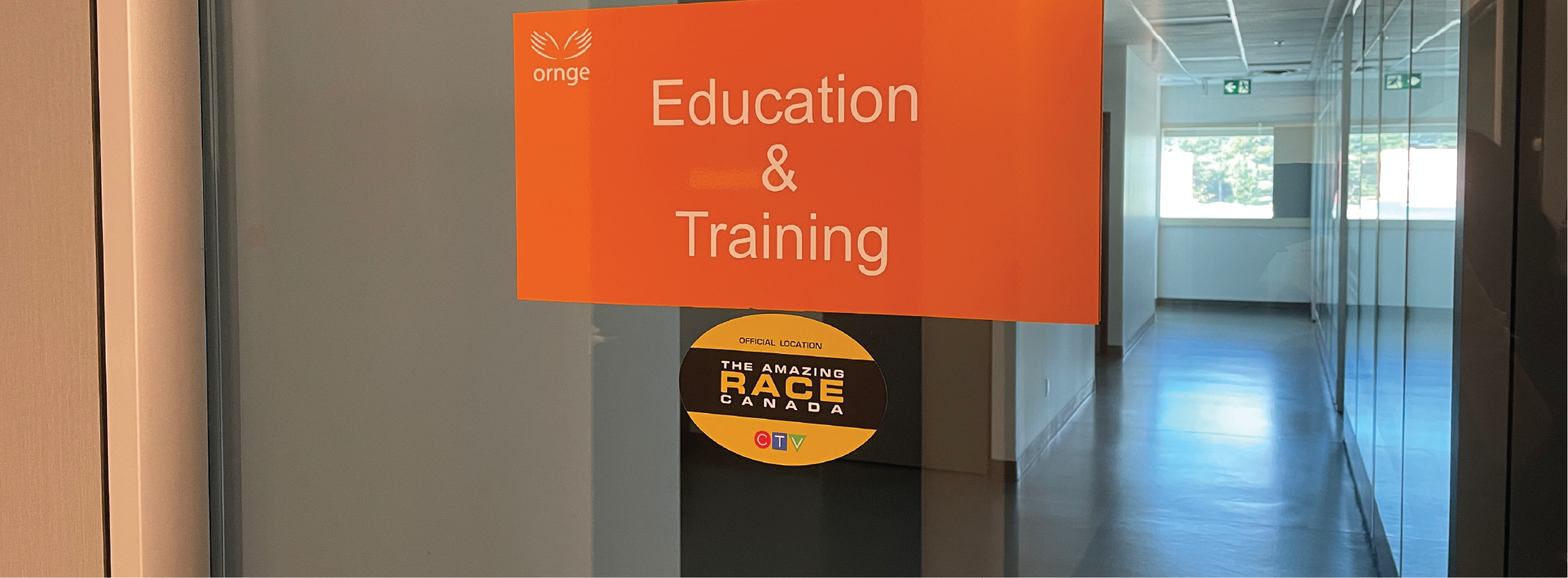 Orange sign that reads 'Education & Training' with a sticker of the Amazing Race Canada logo