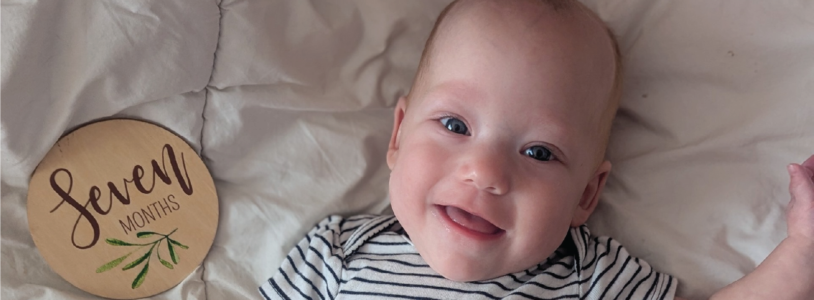 Baby Edith lying on a blanket smiling. 