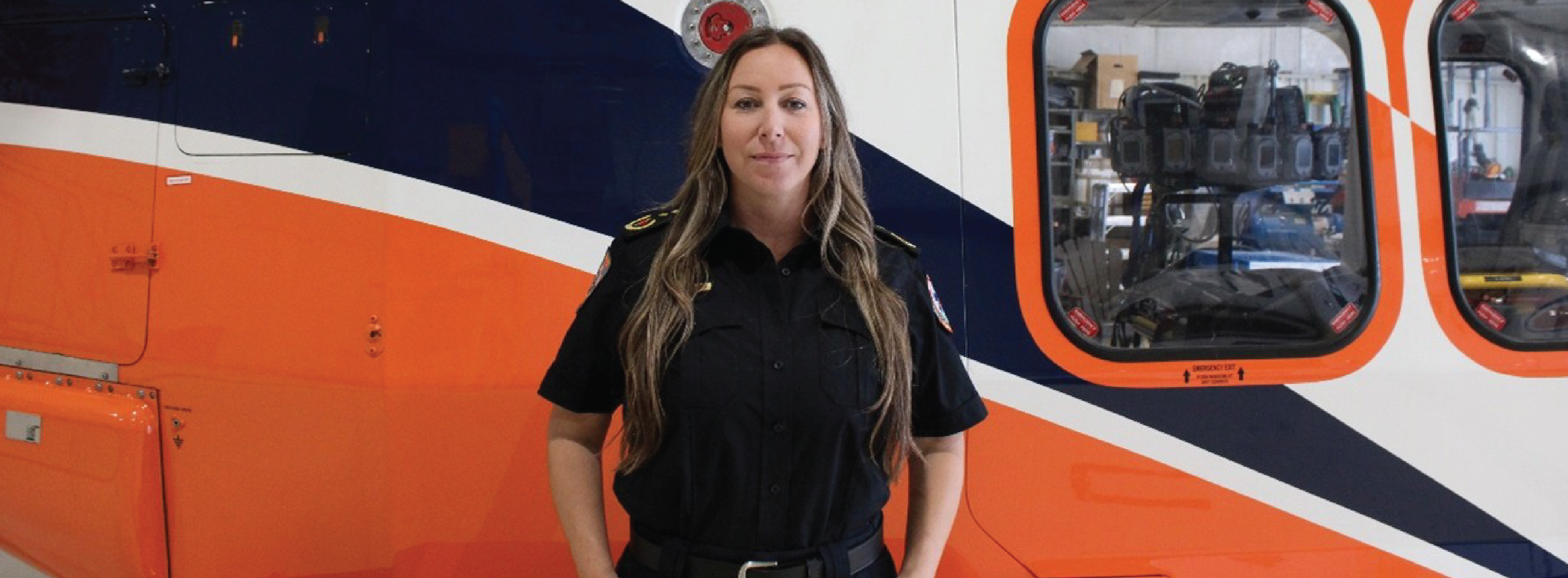Kate Cunningham standing in front of an Ornge helicopter.