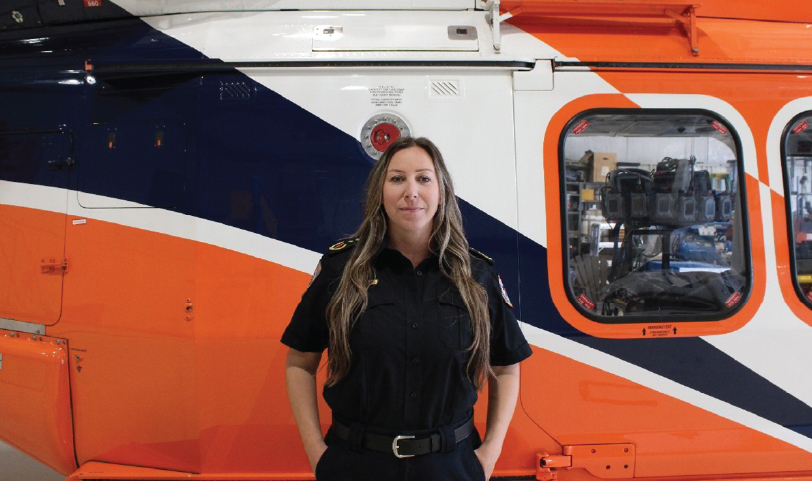 Kate Cunningham standing in front of an Ornge helicopter.