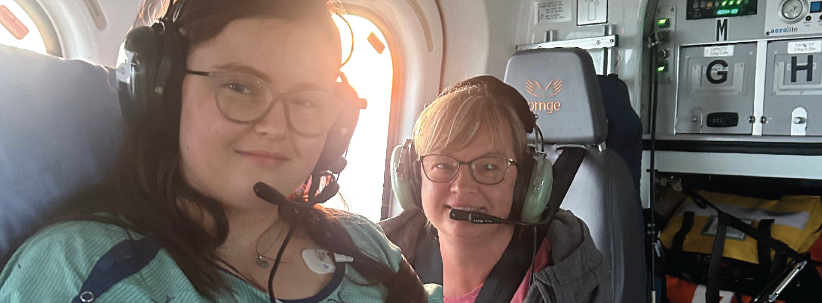 Emma and her mom in the back of a helicopter