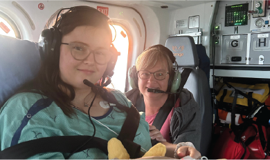 Emma and her mom in the back of a helicopter