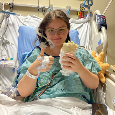 Emma in the hospital eating a wrap