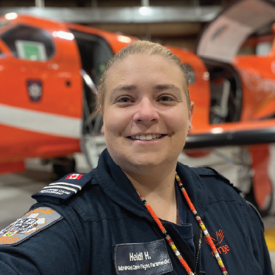 a paramedic in uniform standing in front of an orange plane