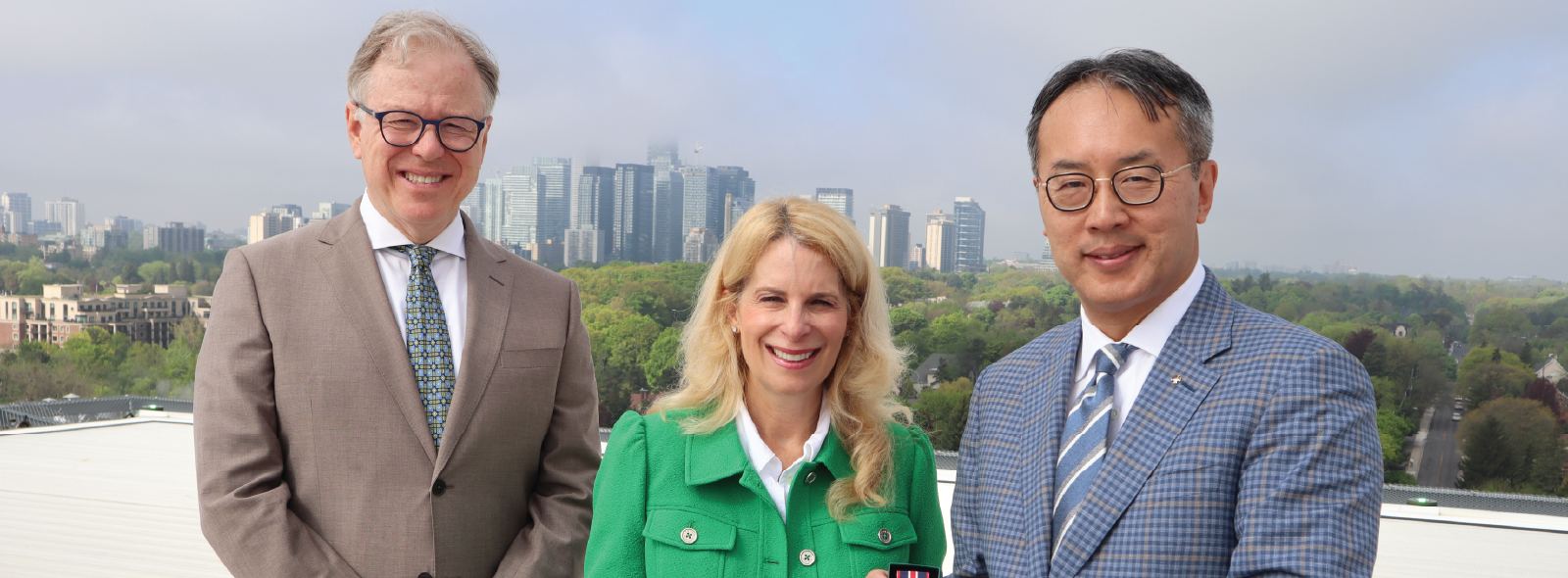 three people standing on a helipad where an award is being presented