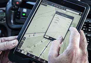 Man looking at an tablet screen in a cockpit of an aircraft