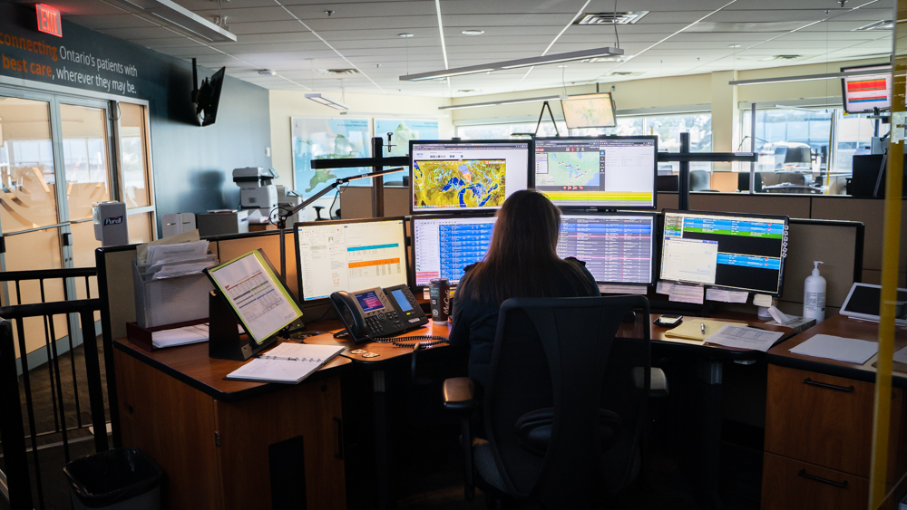 Back view of person sitting at desk in front of computers 